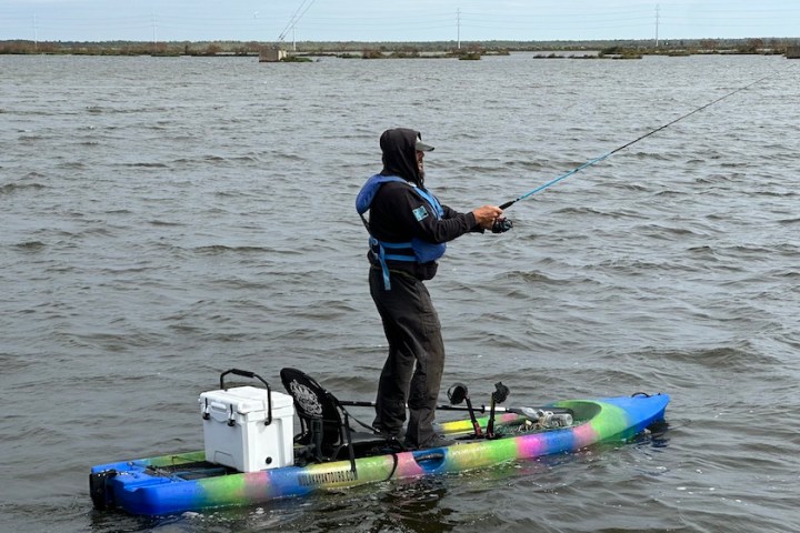a man riding on the back of a boat in a body of water